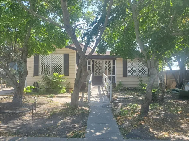 a view of a house with a tree in front