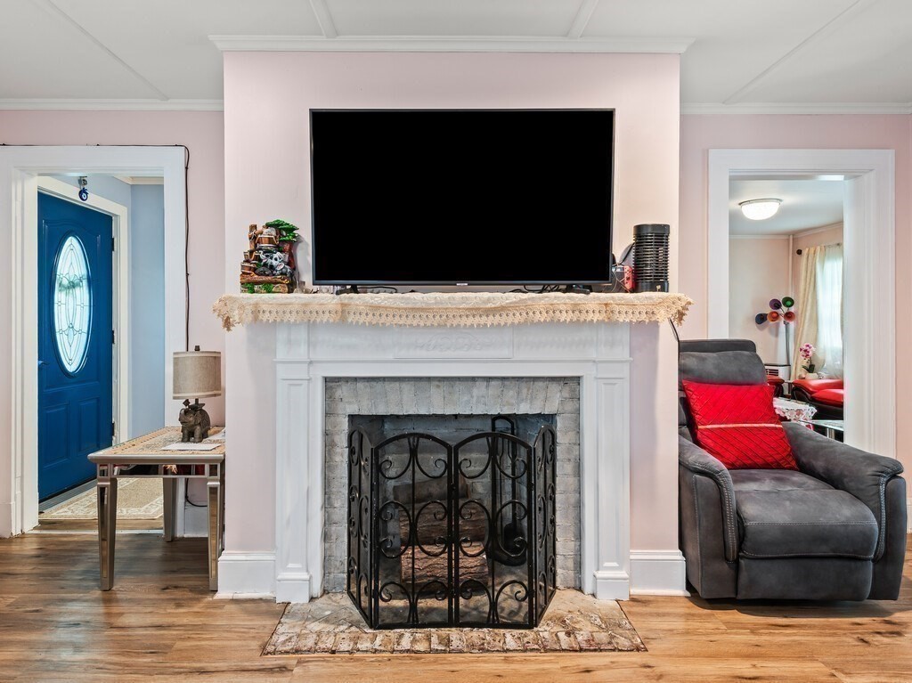 28 Maple Street Southbridge, MA 01550 - Photo 6 of 36 a living room with furniture a flat screen tv and a fireplace