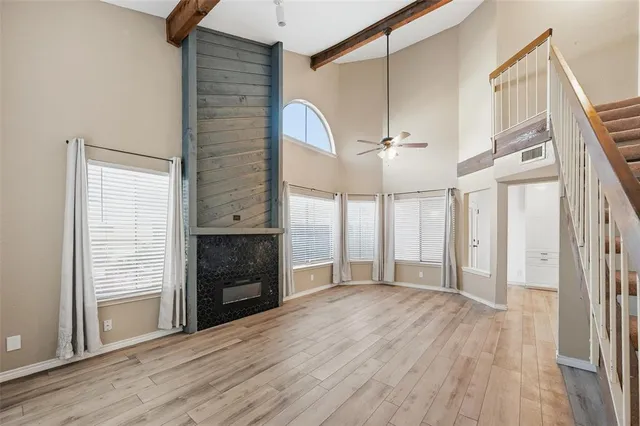 a view of an empty room with a fireplace and a window