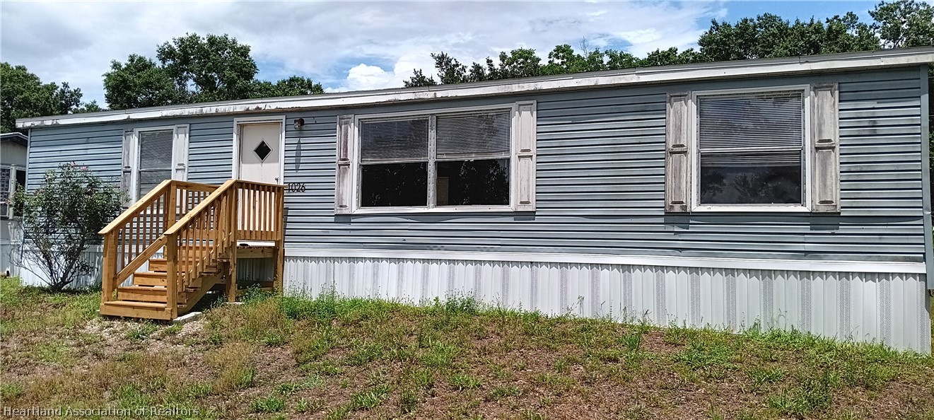 1026 Cardinal Road Wauchula, FL 33873 - Photo 2 of 12 a view of a house with a small yard and wooden fence