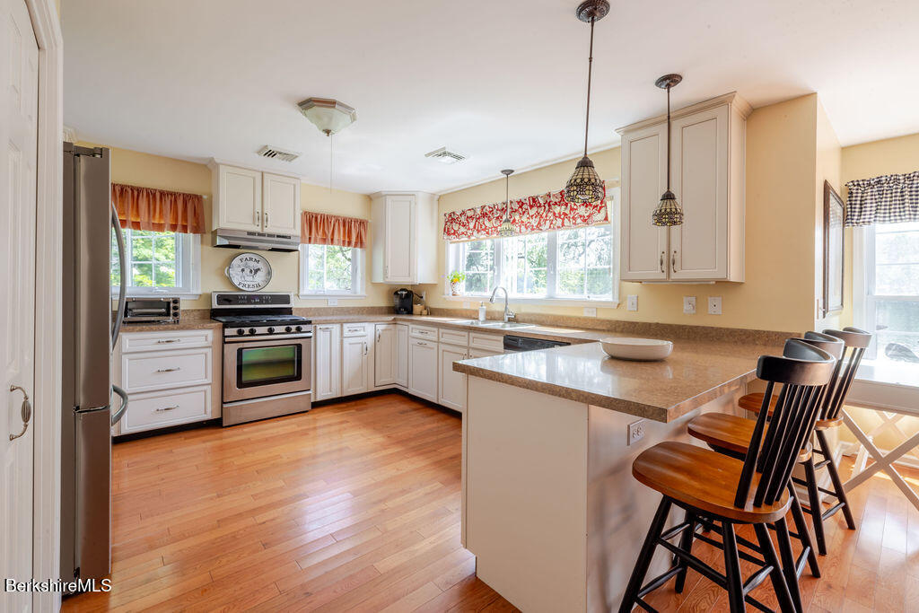 16 Heberts Cove Monterey, MA 01230 - Photo 15 of 47 a kitchen with stainless steel appliances kitchen island granite countertop a stove a sink and a refrigerator
