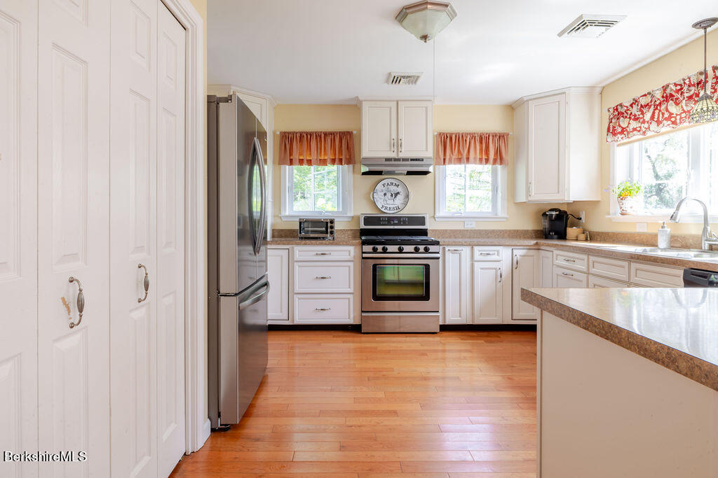 16 Heberts Cove Monterey, MA 01230 - Photo 16 of 47 a kitchen with stainless steel appliances granite countertop a stove a sink and a refrigerator
