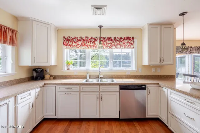 a kitchen with white cabinets and a window