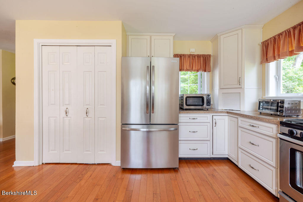 16 Heberts Cove Monterey, MA 01230 - Photo 18 of 47 a kitchen with appliances wooden floor and window