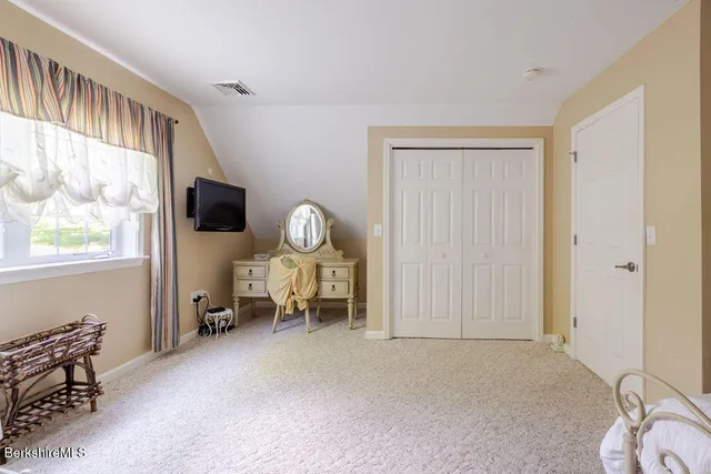 a living room with furniture a flat screen tv and a window