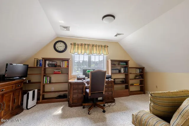 a view of a workspace with furniture and a window