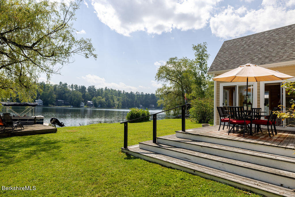 16 Heberts Cove Monterey, MA 01230 - Photo 39 of 47 a view of a lake with a table and chairs under an umbrella
