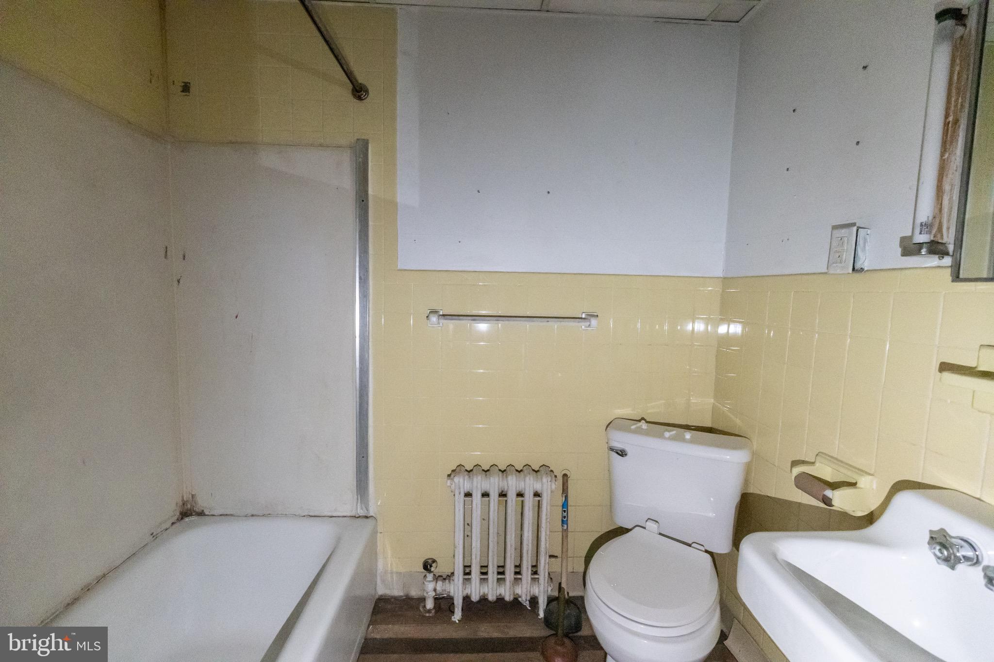 212 West Market Street, Unit A Pottsville, PA 17901 - Photo 8 of 10 a white toilet sitting next to a bathroom sink and a shower