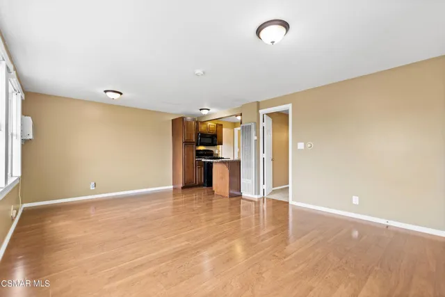 a view of an empty room with kitchen