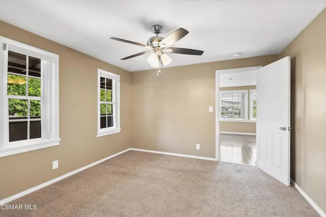 a view of an empty room with window and cabinet