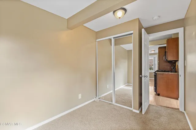 an empty room with closet and a ceiling fan