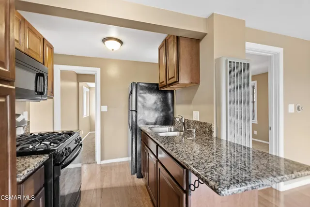 a kitchen with stainless steel appliances granite countertop a sink stove and refrigerator
