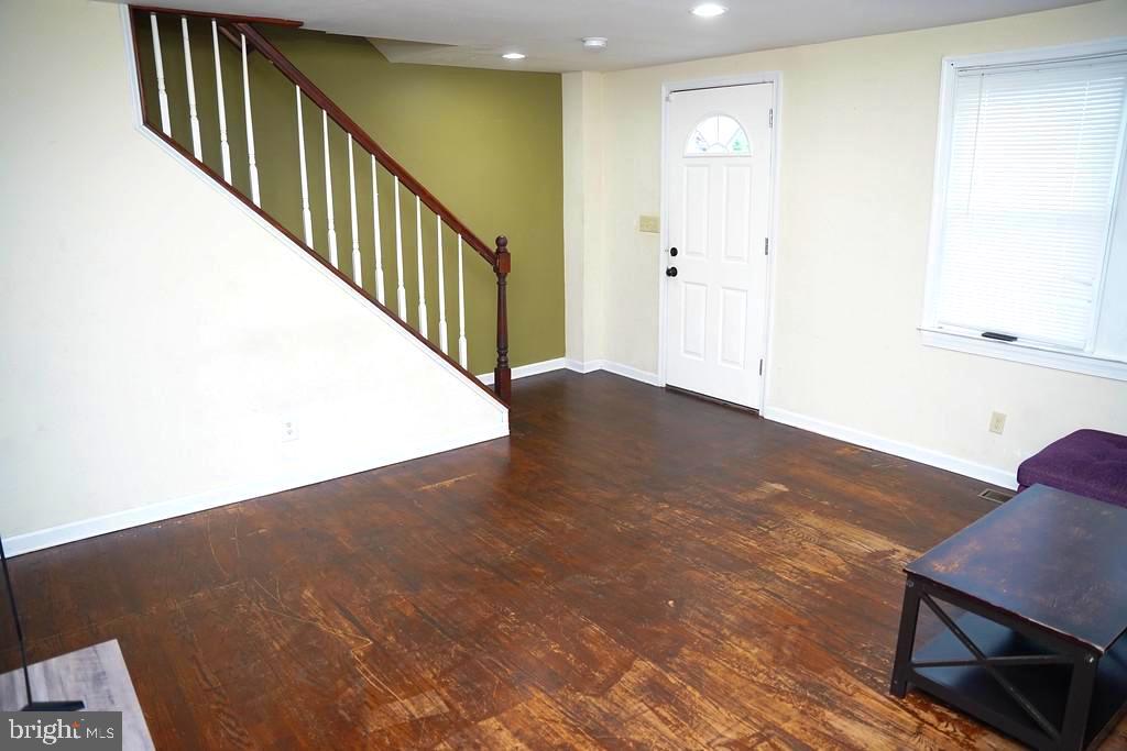 3814 Erdman Avenue Baltimore, MD 21213 - Photo 3 of 18 a view of a hallway with wooden floor and windows