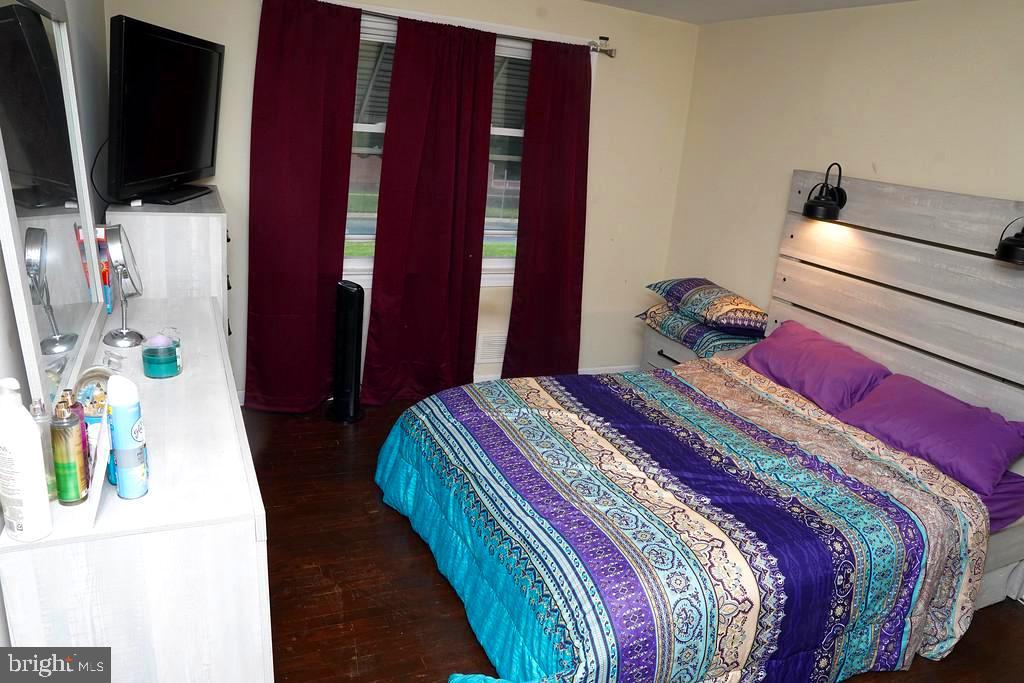 3814 Erdman Avenue Baltimore, MD 21213 - Photo 10 of 18 a bedroom with a bed and flat screen tv
