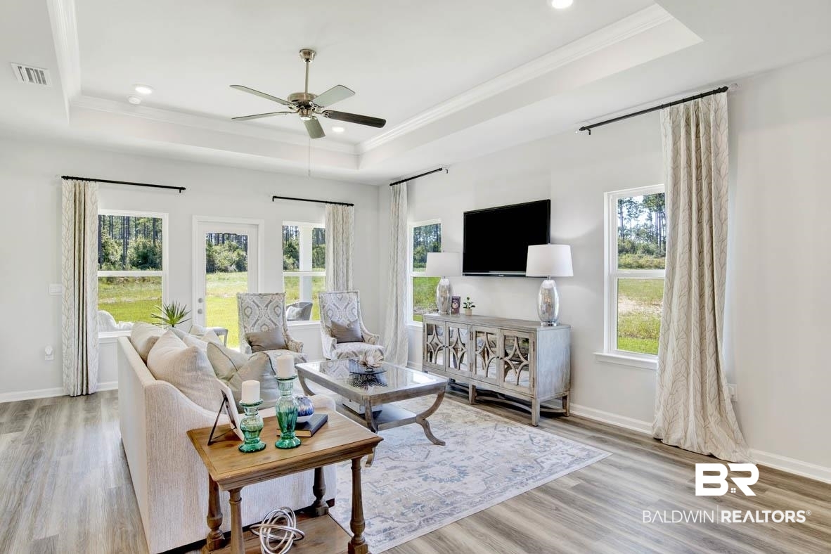 13822 Antler Hl Road Daphne, AL 36527 - Photo 25 of 39 Living room with light wood-type flooring, a tray ceiling, ceiling fan, and a healthy amount of sunlight