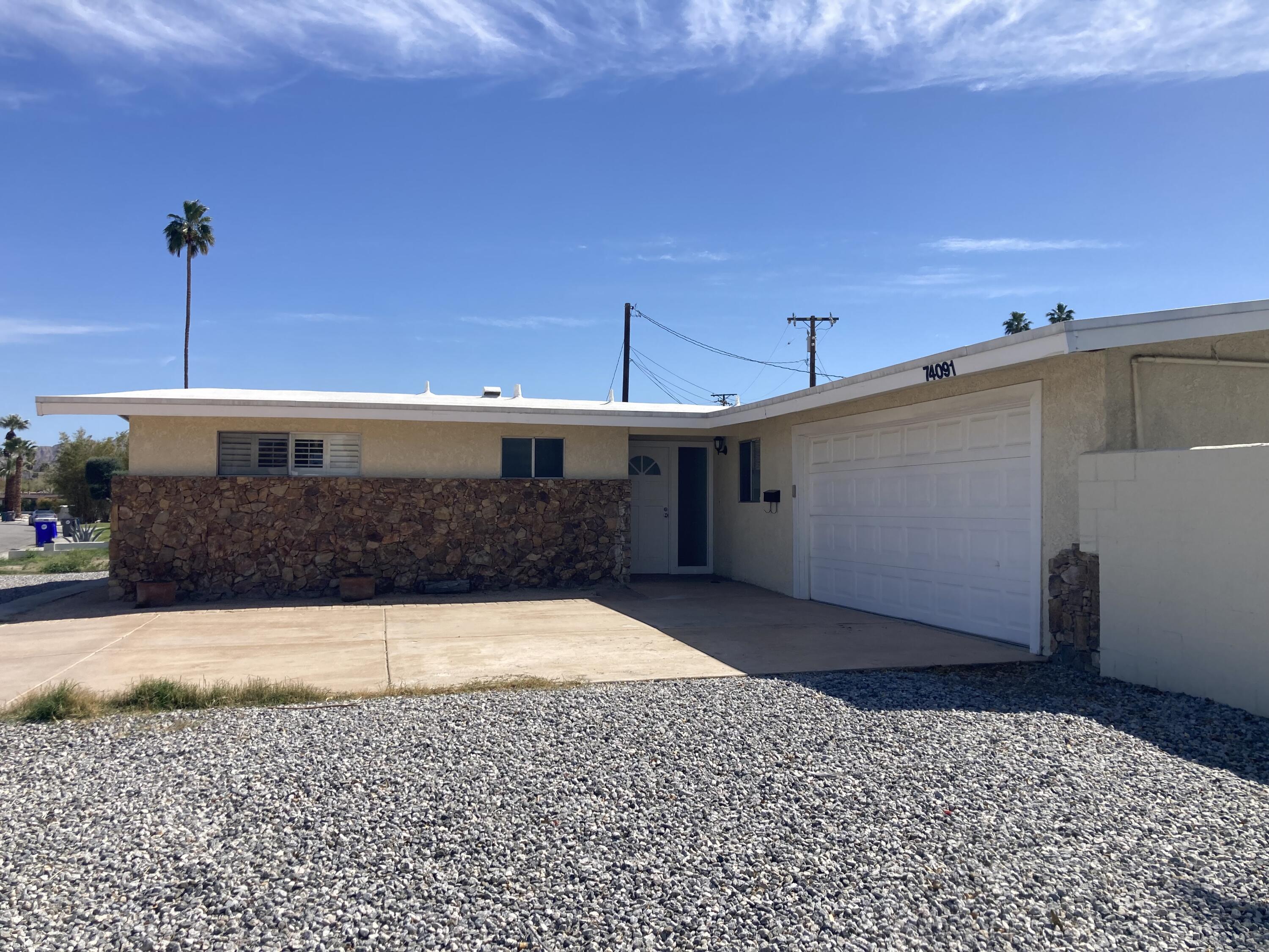 74091 Aster Drive Palm Desert, CA 92260 - Photo 13 of 16 a front view of a house with a yard