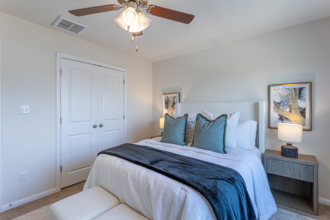 17927 Papaveri Way Pflugerville, TX 78660 - Photo 19 of 26 a bedroom with bed and a chandelier