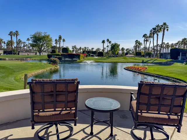 a view of a chairs and table in patio with a lake view