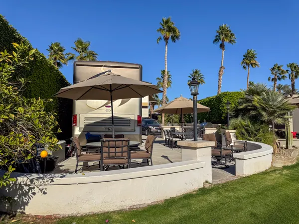 a view of a chairs and table in the patio and a garden