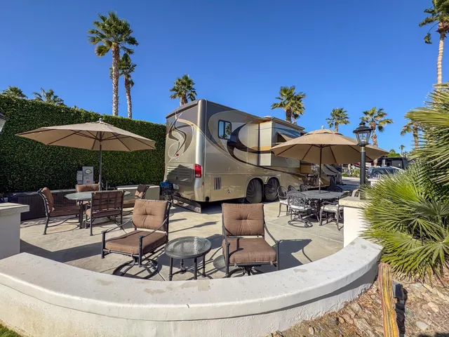a view of a patio with furniture and table under an umbrella