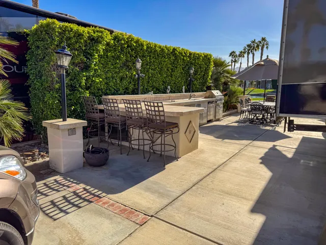 a view of a patio with chairs and potted plants
