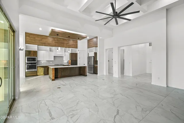 a large kitchen with stainless steel appliances granite countertop a refrigerator and a sink