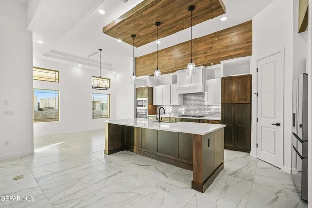 a large kitchen with stainless steel appliances kitchen island granite countertop a sink and cabinets