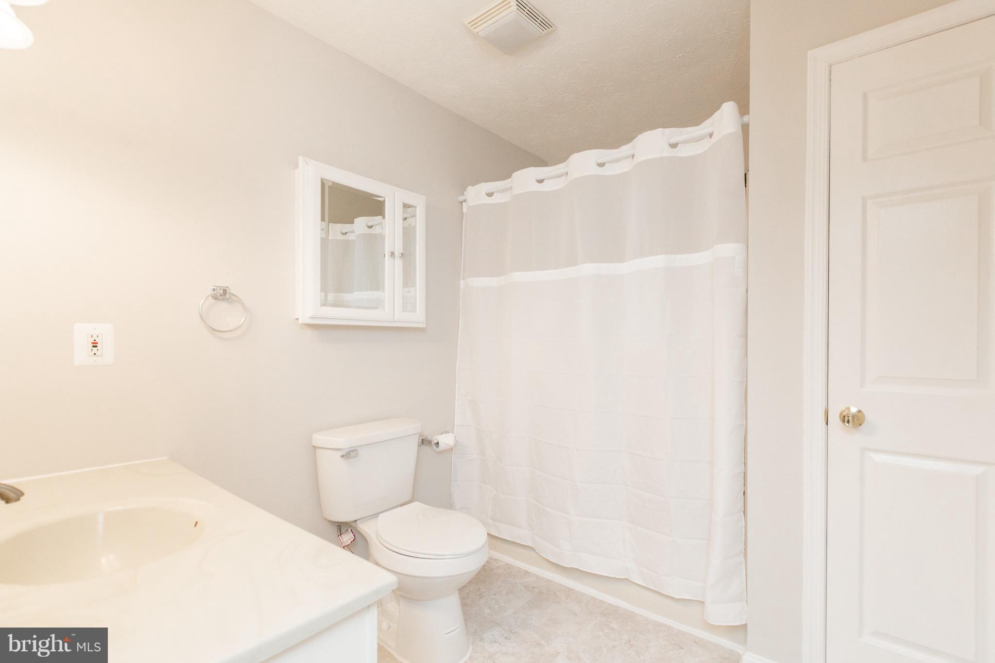 75 Locust Tree Lane Front Royal, VA 22630 - Photo 13 of 27 a white toilet sitting next to a bathroom sink and vanity