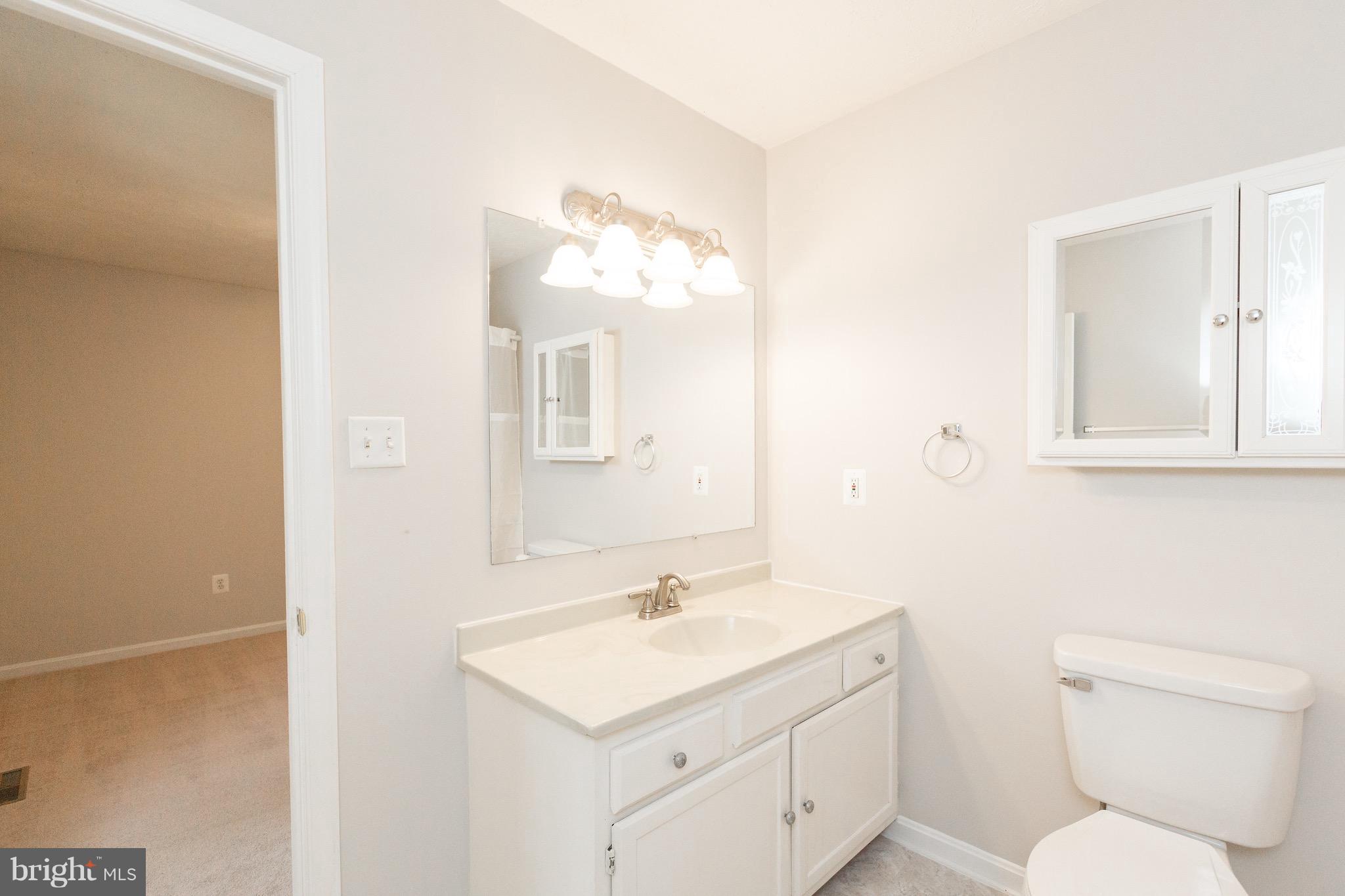 75 Locust Tree Lane Front Royal, VA 22630 - Photo 14 of 27 a bathroom with a toilet a sink and mirror