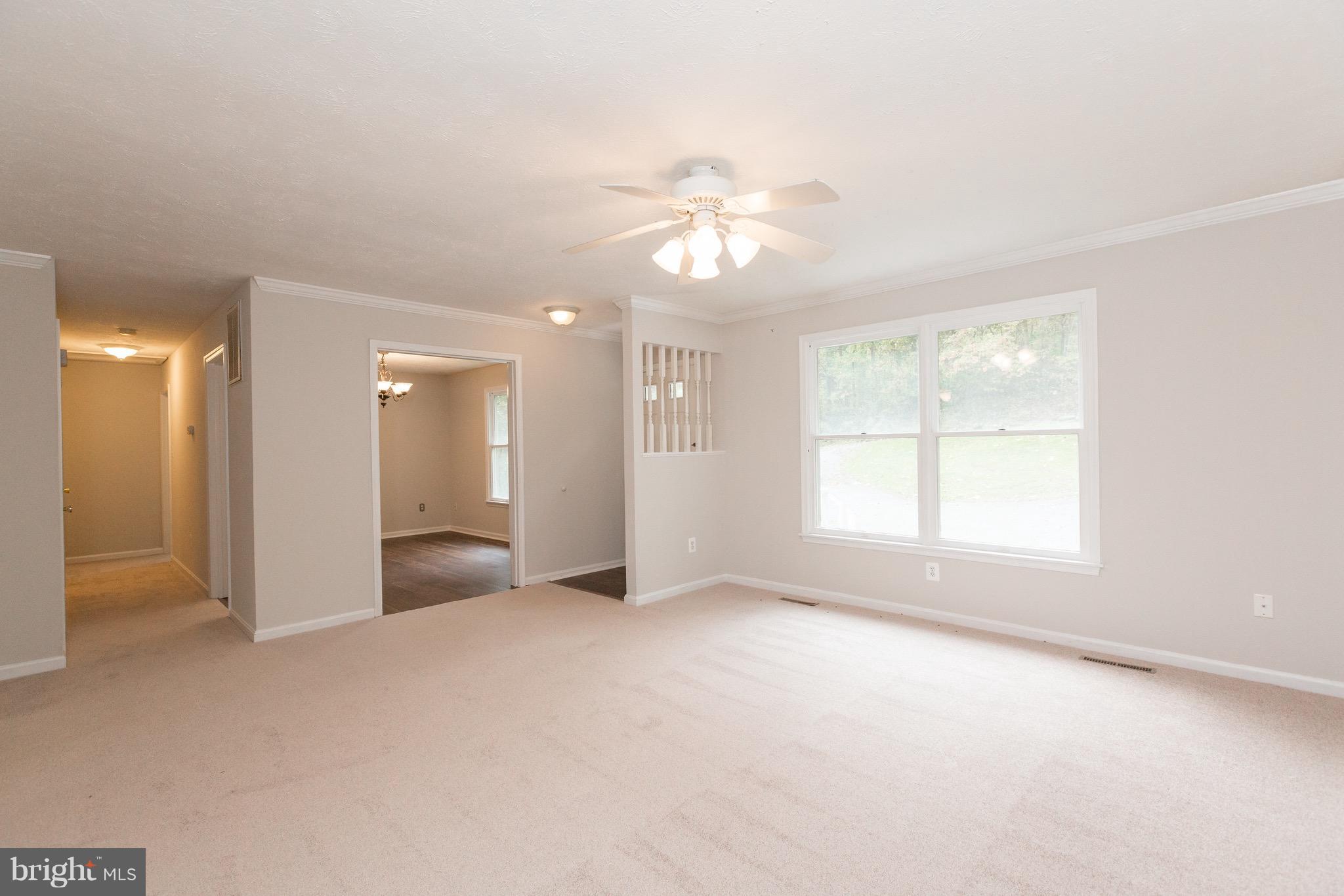 75 Locust Tree Lane Front Royal, VA 22630 - Photo 3 of 27 an empty room with chandelier fan and windows