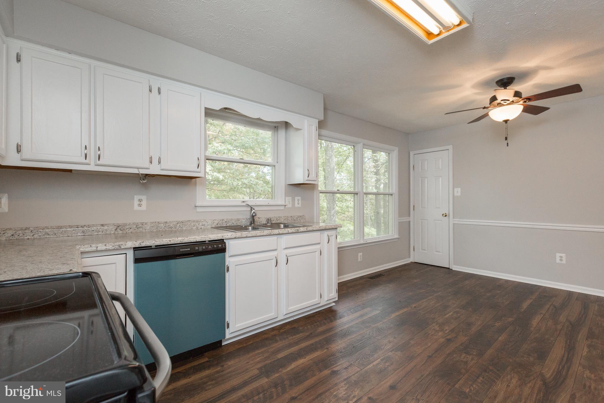 75 Locust Tree Lane Front Royal, VA 22630 - Photo 10 of 27 a kitchen with granite countertop white cabinets a sink a window and appliances