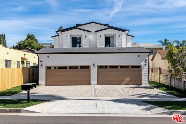 a front view of a house with a garden and garage
