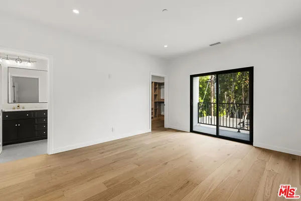 a view of a big room with wooden floor and windows