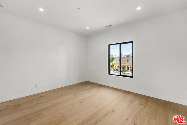 a kitchen with white cabinets and a wooden floor