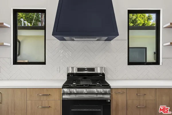 a stove top oven sitting inside of a kitchen