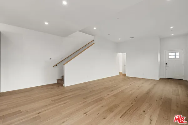 a view of empty room with wooden floor