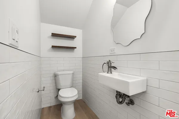 a bathroom with a sink a toilet and mirror