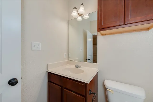 a bathroom with a sink a toilet and mirror
