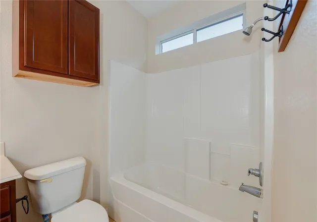 a white toilet sitting next to a bath tub