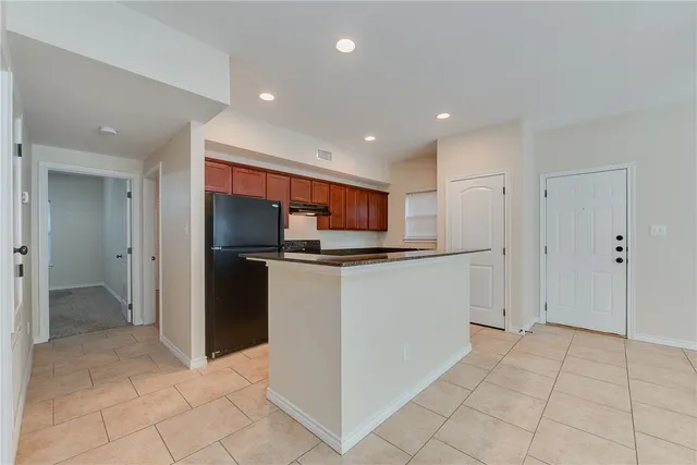 a kitchen with stainless steel appliances kitchen island sink and refrigerator