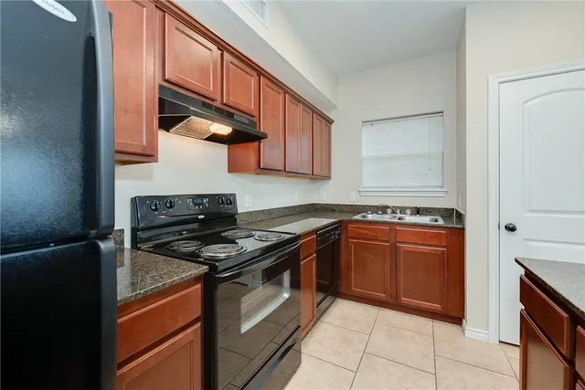a kitchen with stainless steel appliances granite countertop a stove and a refrigerator