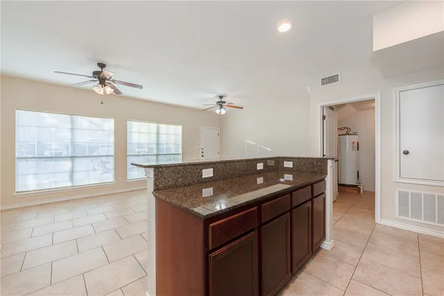 a kitchen with granite countertop a sink and a refrigerator