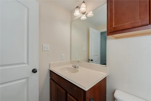 a bathroom with a sink a light fixture and a mirror