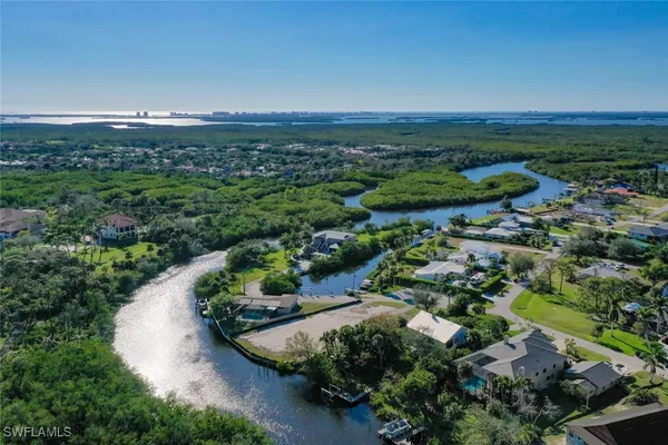 an aerial view of residential houses with outdoor space and trees
