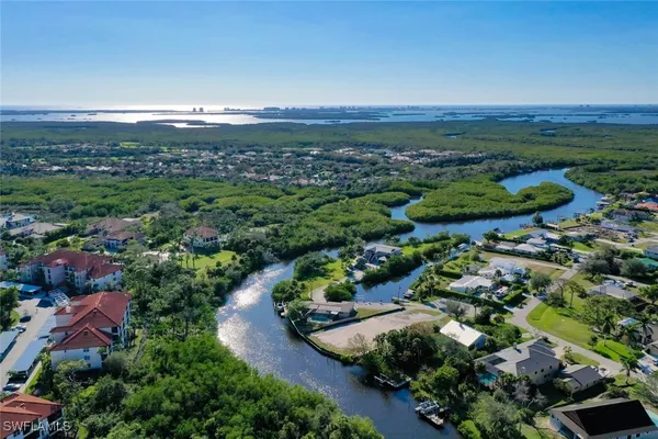 an aerial view of a house with a yard and lake view