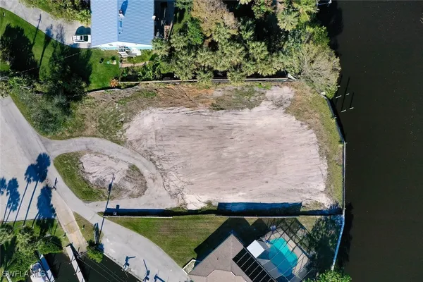 an aerial view of a house with a yard and lake view