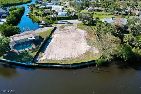 an aerial view of residential houses with outdoor space and lake view
