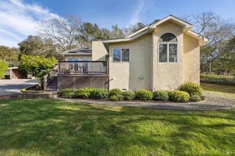 a front view of a house with a yard and potted plants