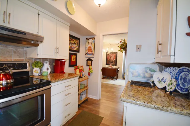 a kitchen with stainless steel appliances granite countertop a sink stove and cabinets