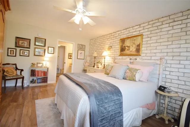 a spacious bedroom with a bed and wooden floor